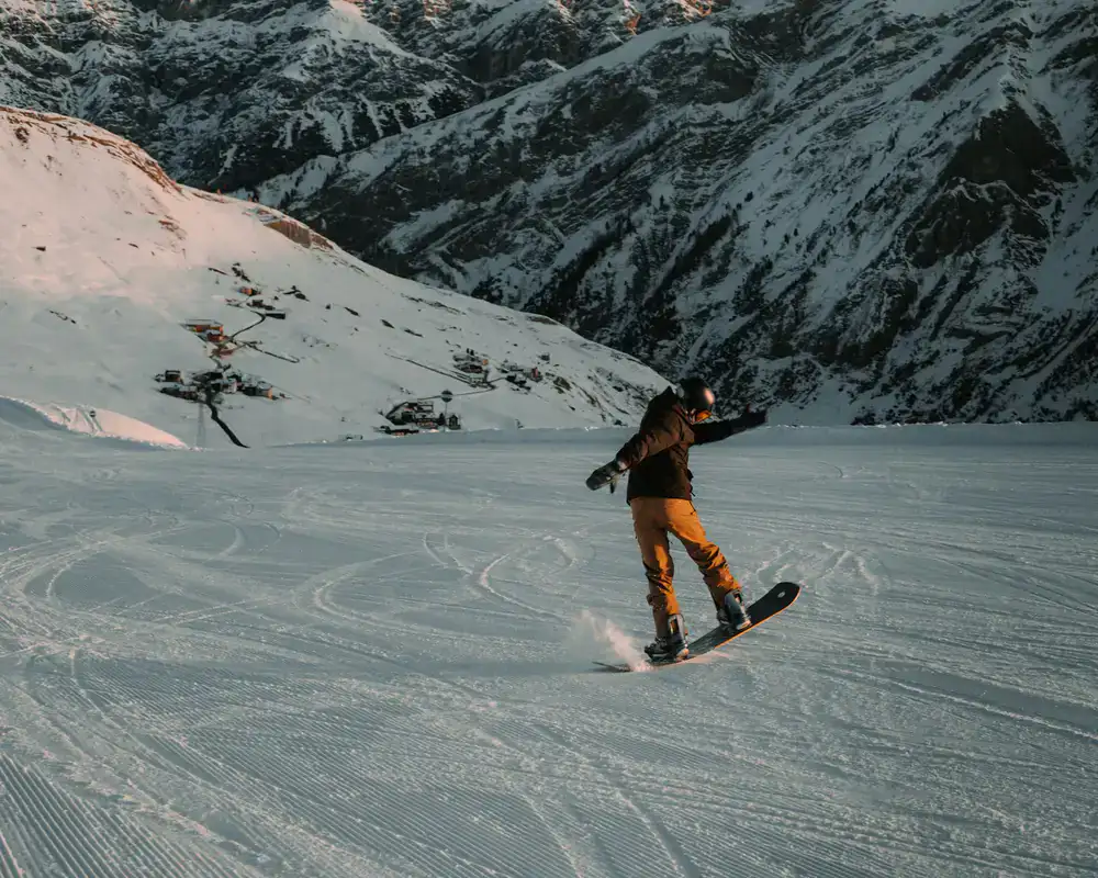 A snowboarder carving through fresh mountain snow